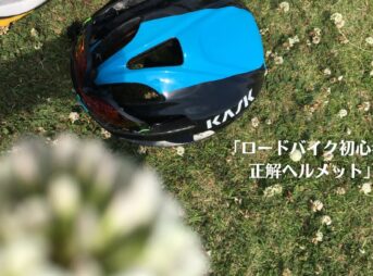 シロツメクサの咲く芝生に置かれた青と黒のKASK（カスク）ヘルメットに、「ロードバイク初心者の正解ヘルメット」と記されたアイキャッチ。最初の装備選びに迷う読者へ向け、安全性とデザイン性を備えたおすすめ機材を解説するレビュー記事の表紙。