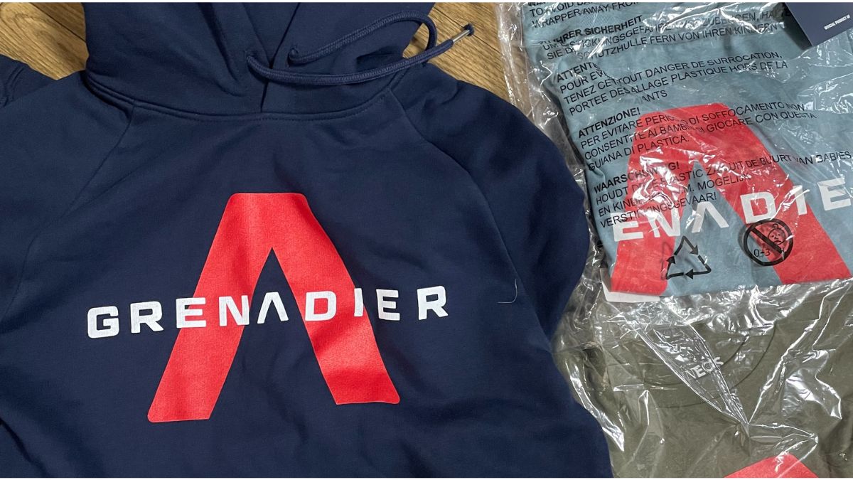 INEOS Grenadiersのネイビーのパーカーと、パッケージに入ったTシャツ2枚の写真。海外通販で無事に届いた購入品一式です。