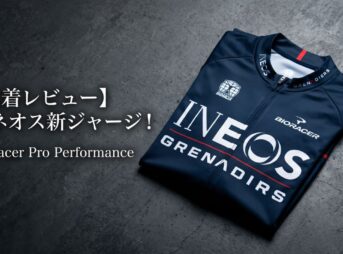 洗練された背景に置かれたネイビー色のイネオス・グレナディアーズ公式ジャージ。「実着レビュー」の文字を添え、初心者がプロ仕様のウェアを選ぶ際の着心地やサイズ感の不安を解消する、丁寧な解説記事の顔となるデザイン。
