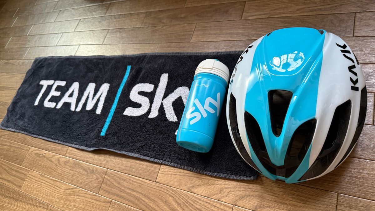 お気に入りのチームスカイのタオルとボトル、静かに出番を待つ愛用のKASKヘルメット。自転車に乗る時だけでなく、普段の生活でも大好きなチームのグッズに触れ、自由気ままなソロライドへ出発する日を心待ちにする、豊かでワクワクする情景。